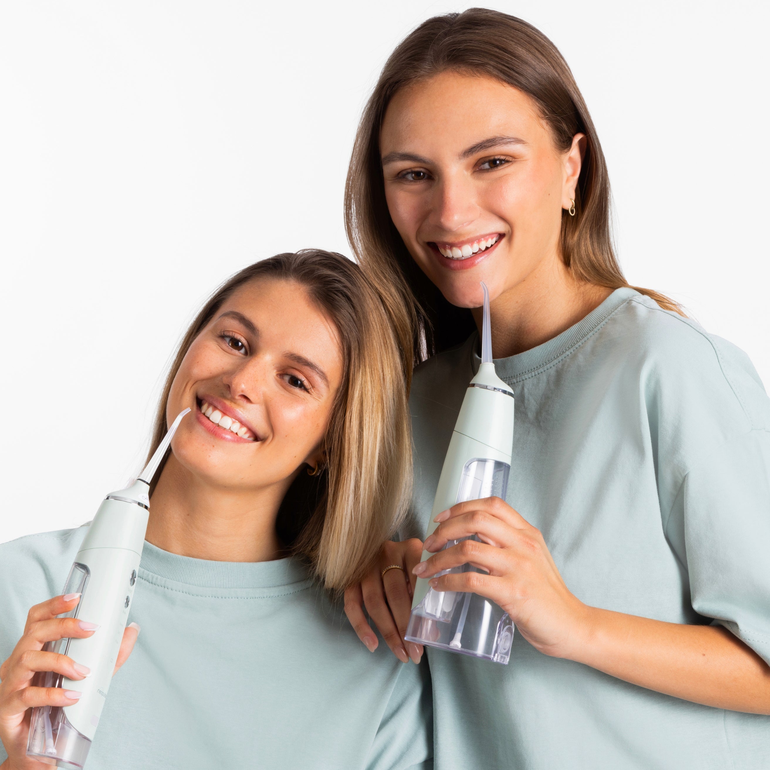 Deux femmes souriantes utilisant les jets dentaires MY FIRST et EASY de couleur verte