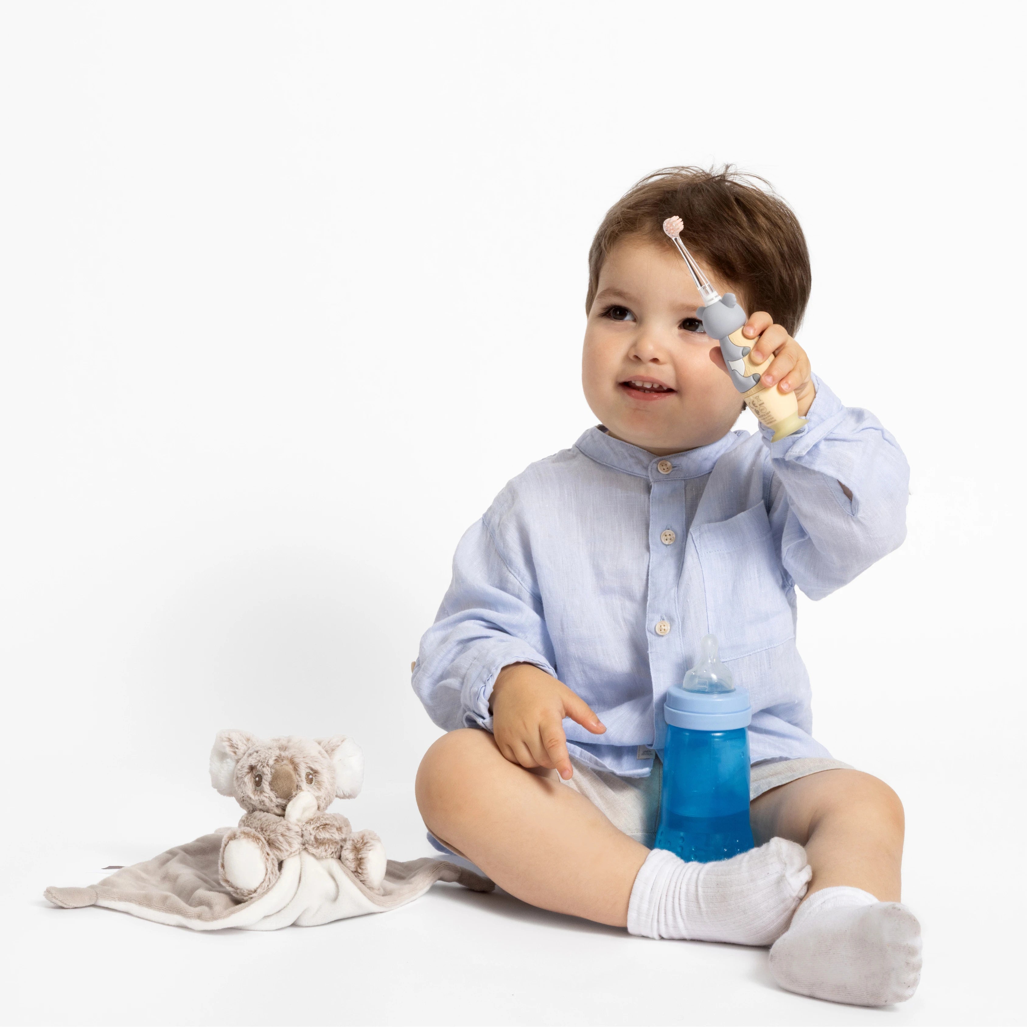 Un bébé tient dans la main la brosse à dents à vibrations NEOBABY